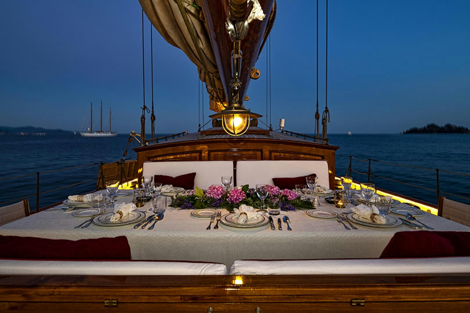 a table with plates and flowers on it aboard INVADER Yacht for Charter