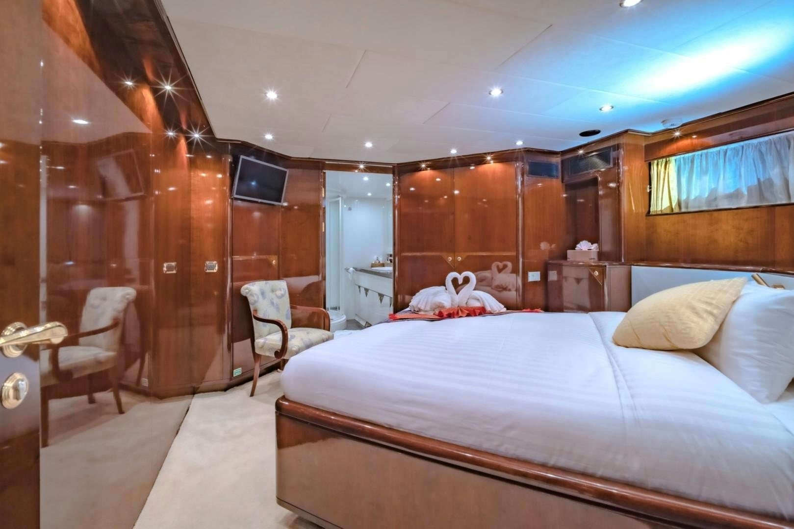 a bedroom with a bed and a television aboard XANADU OF LONDON Yacht for Sale