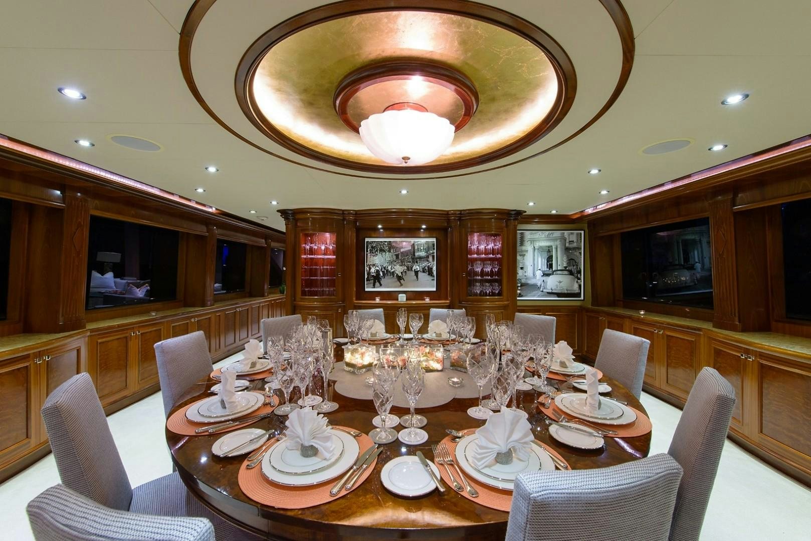 a large dining room with a chandelier aboard FAR FROM IT Yacht for Charter