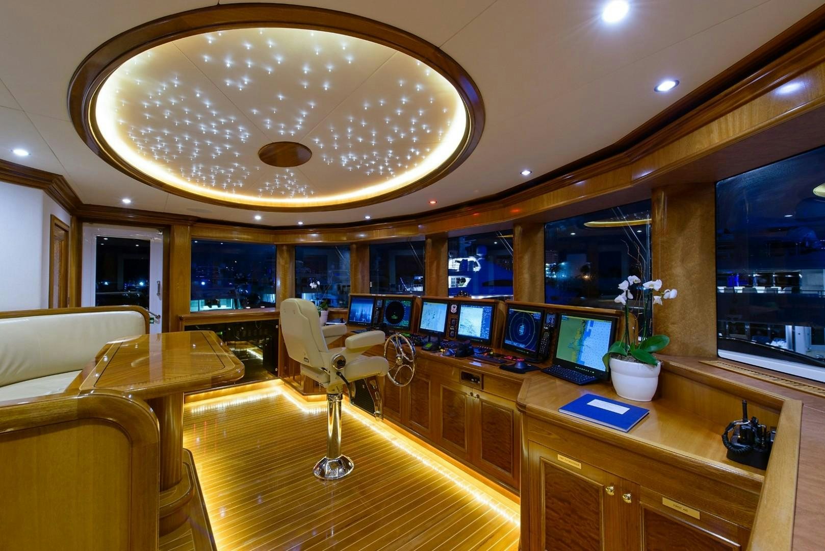 a large room with a chandelier and a table aboard FAR FROM IT Yacht for Charter