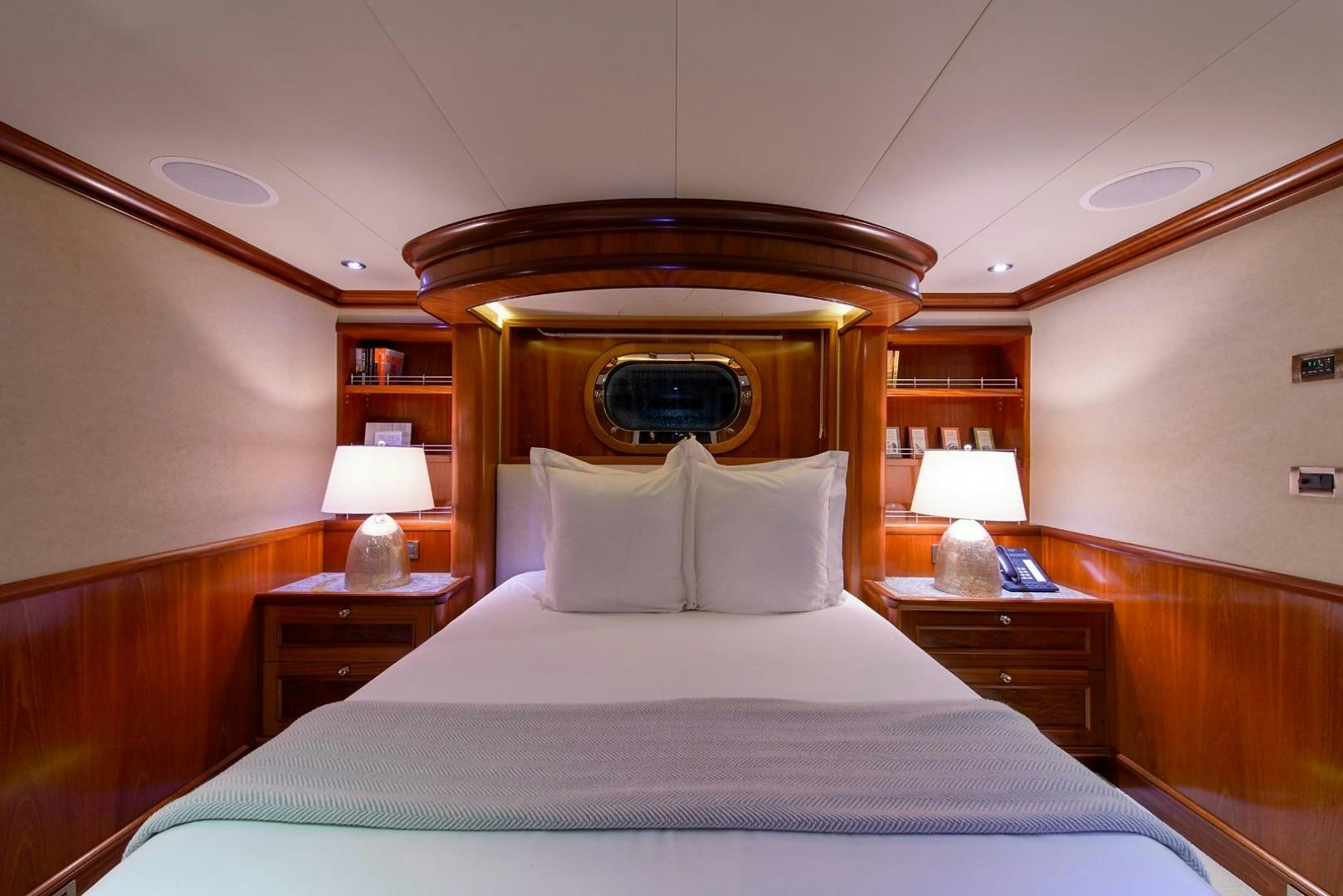a bed with a round mirror above it aboard FAR FROM IT Yacht for Charter