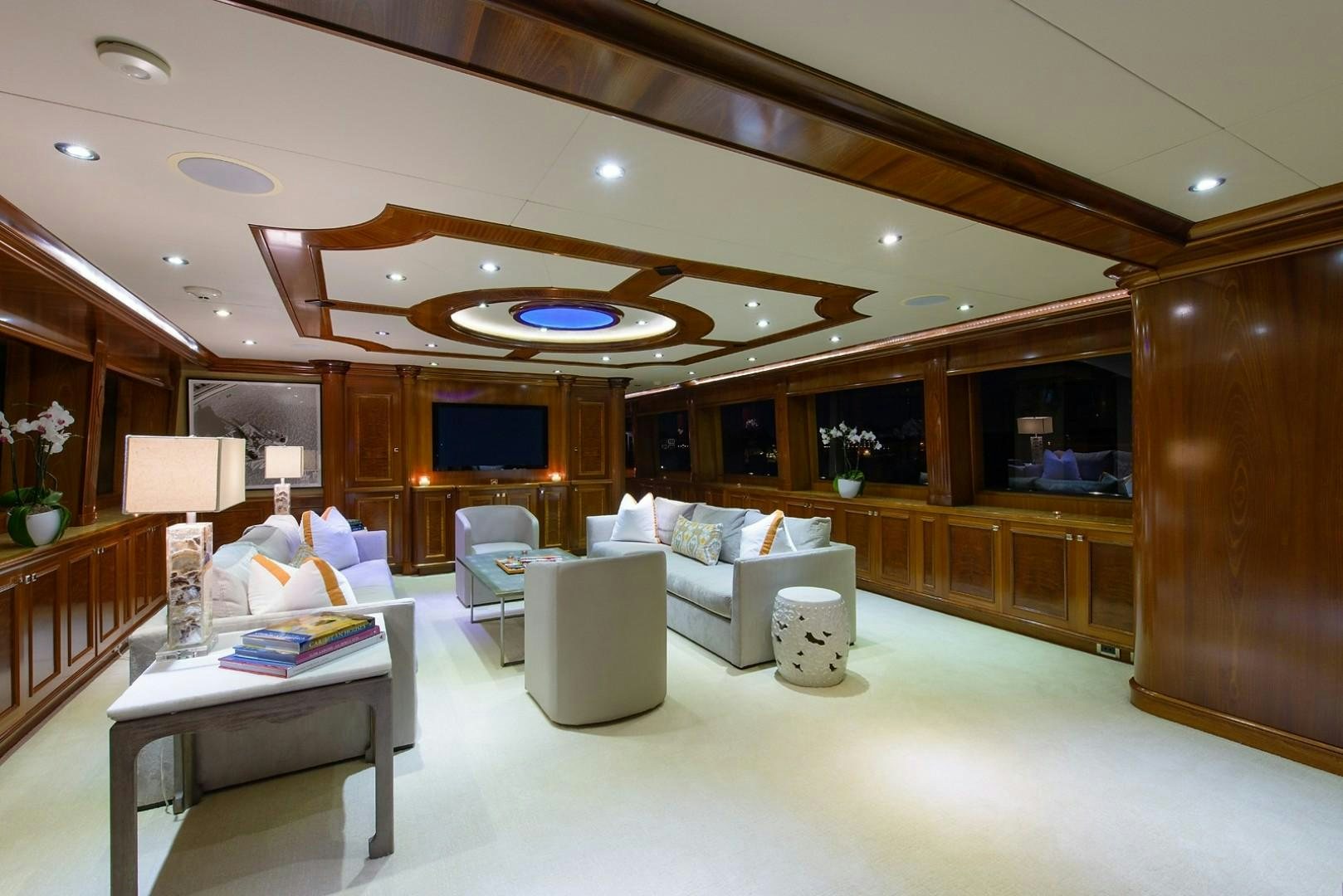 a room with a couch and a table and a television aboard FAR FROM IT Yacht for Charter