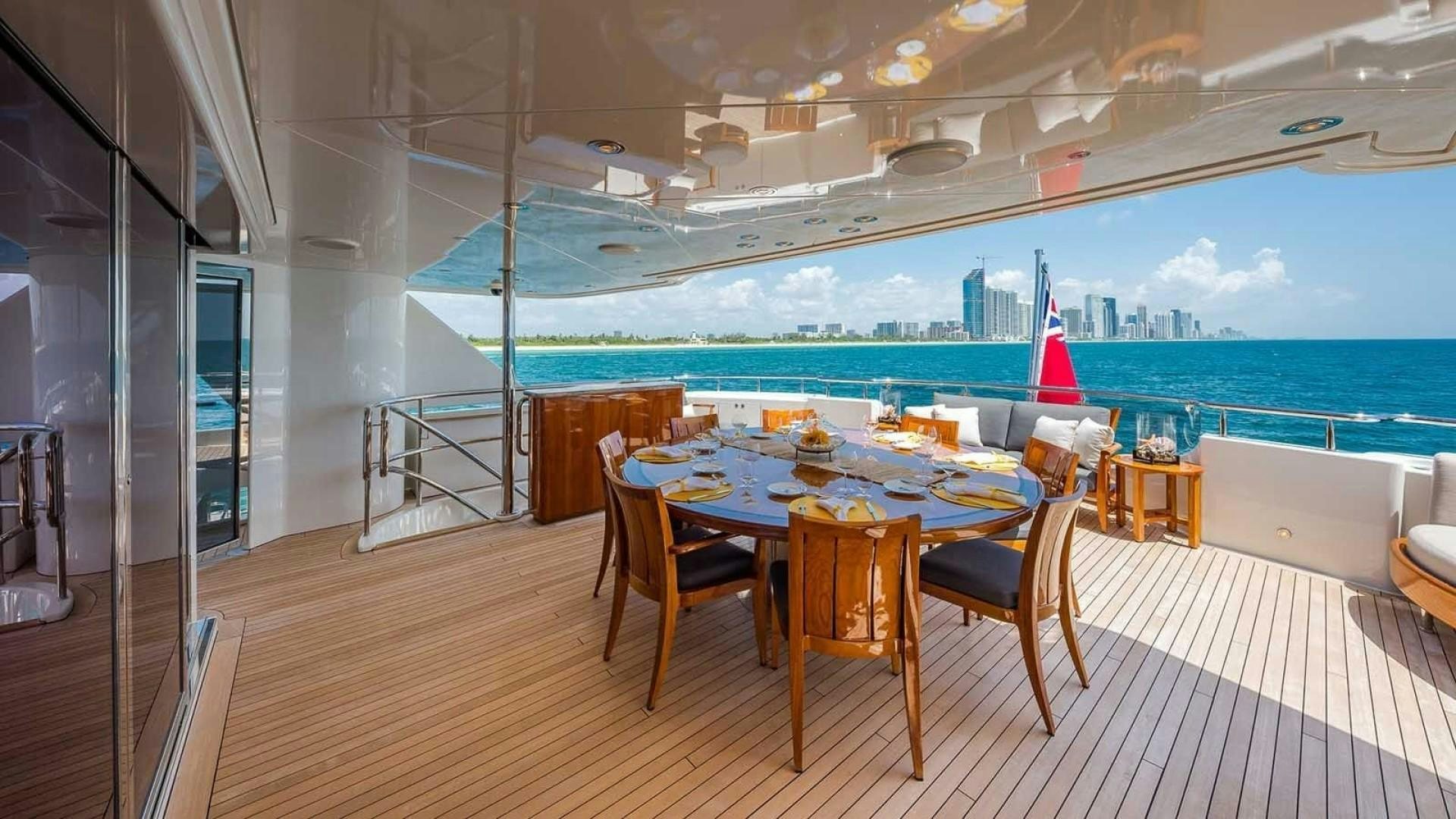 a table and chairs on a deck overlooking a city aboard AS YOU WISH Yacht for Charter