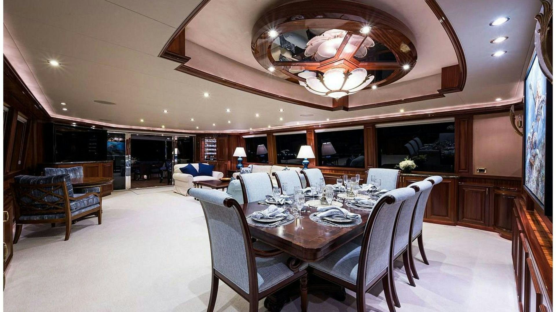 a large dining room with a chandelier above it aboard NOW OR NEVER Yacht for Charter