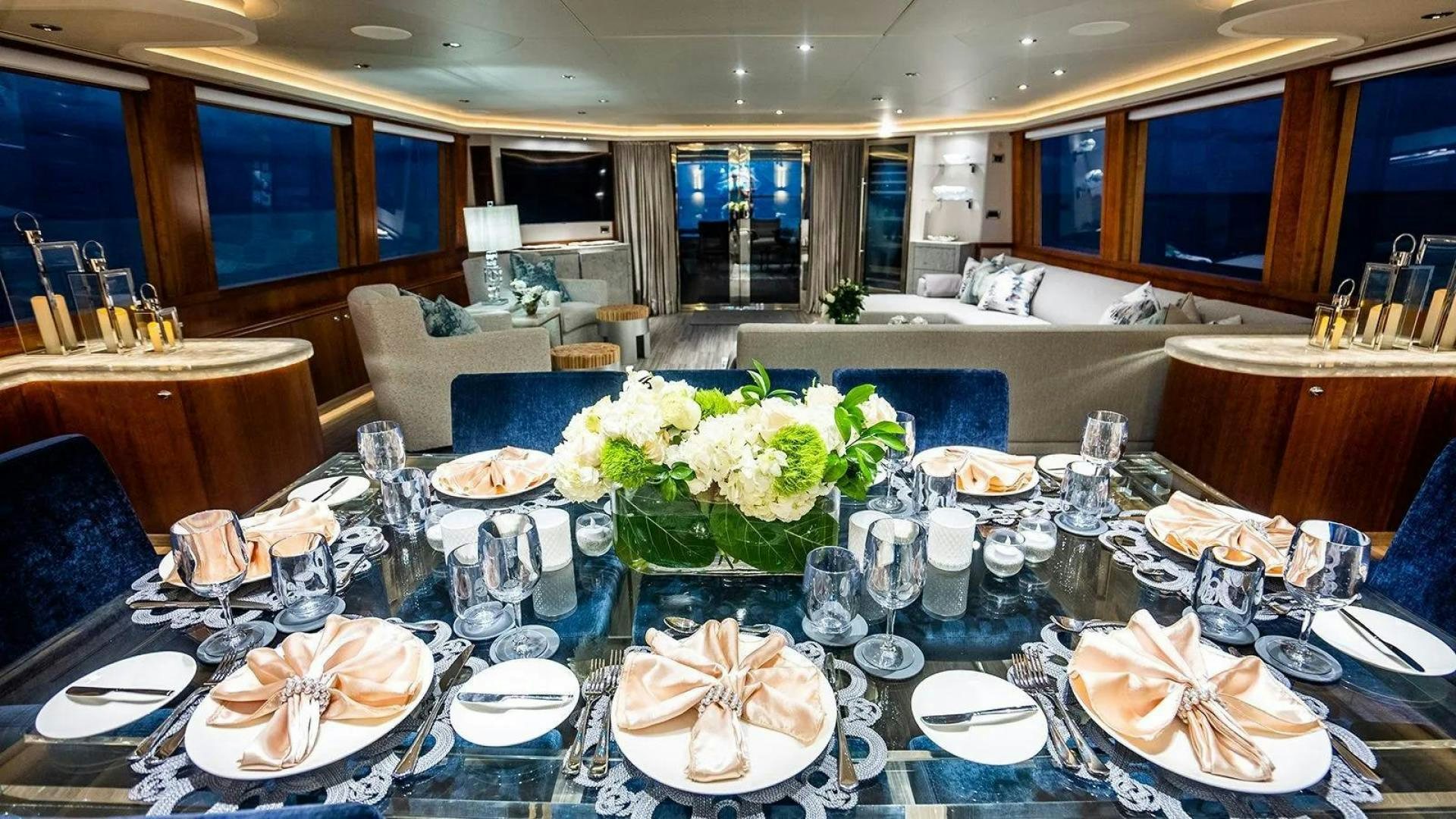 a large table with plates and glasses aboard KEMOSABE Yacht for Charter