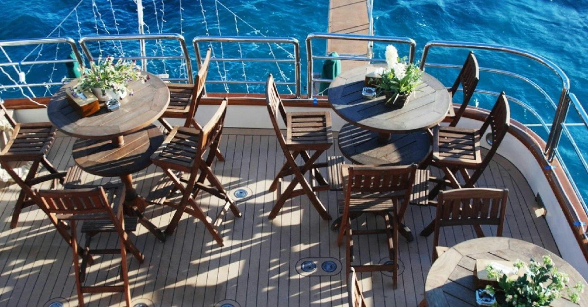 a table set with chairs and a pool aboard FORTY LOVE Yacht for Charter