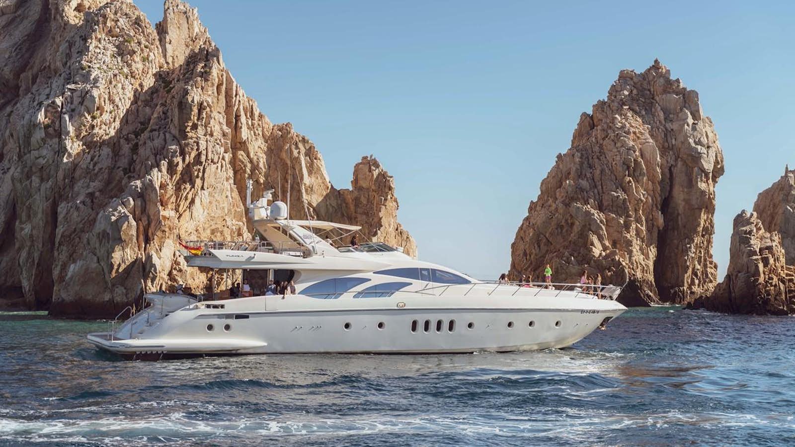 a boat in the water with Arch of Cabo San Lucas in the background aboard GANESH A Yacht for Sale