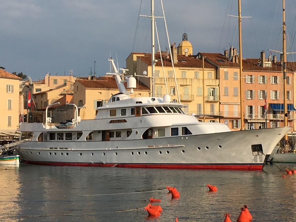 a large white boat in a harbor aboard SEAGULL OF CAYMAN Yacht for Sale