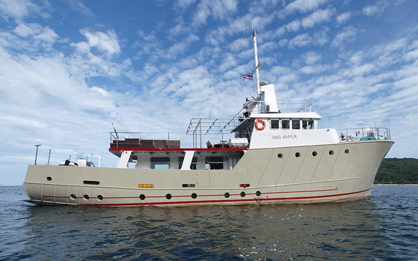 a large white boat on the water aboard KAMA BAY Yacht for Sale
