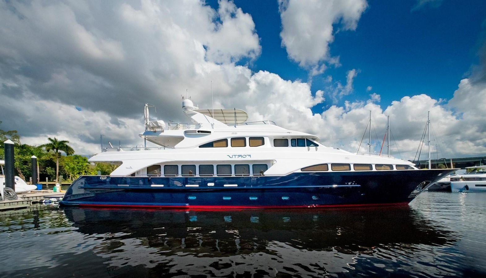a large boat in a harbor aboard FORTIS Yacht for Sale