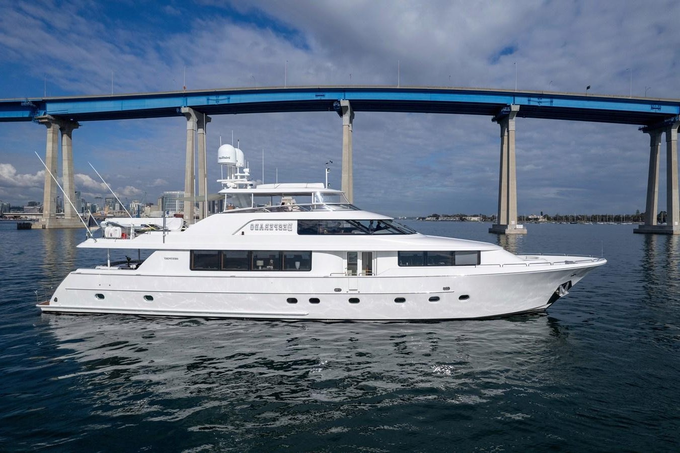 a white yacht under a bridge aboard DESPERADO Yacht for Sale
