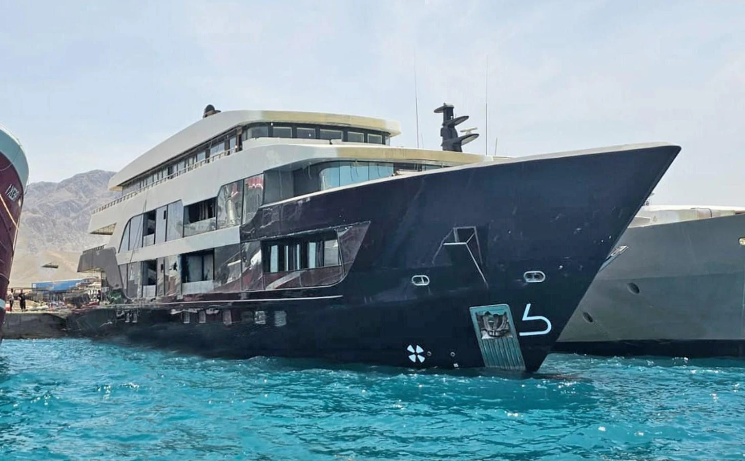 A sleek and modern yacht docked in a serene harbor, showcasing its impressive size and design. aboard JASMINE Yacht for Sale