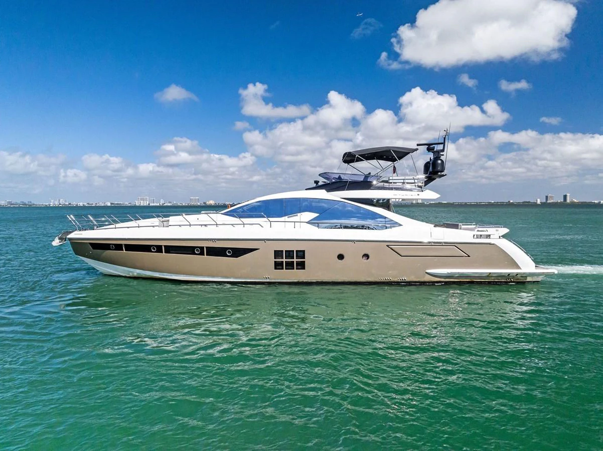 A sleek and modern yacht glides gracefully on the water under a clear blue sky. aboard PANDA Yacht for Sale