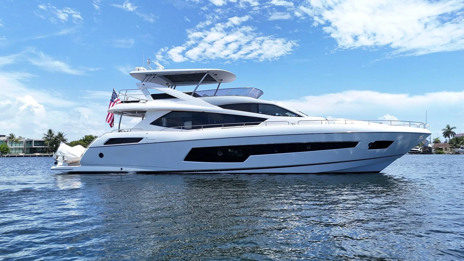 A sleek, modern yacht cruising on calm waters under a bright blue sky. aboard DIRTY DAWG Yacht for Sale
