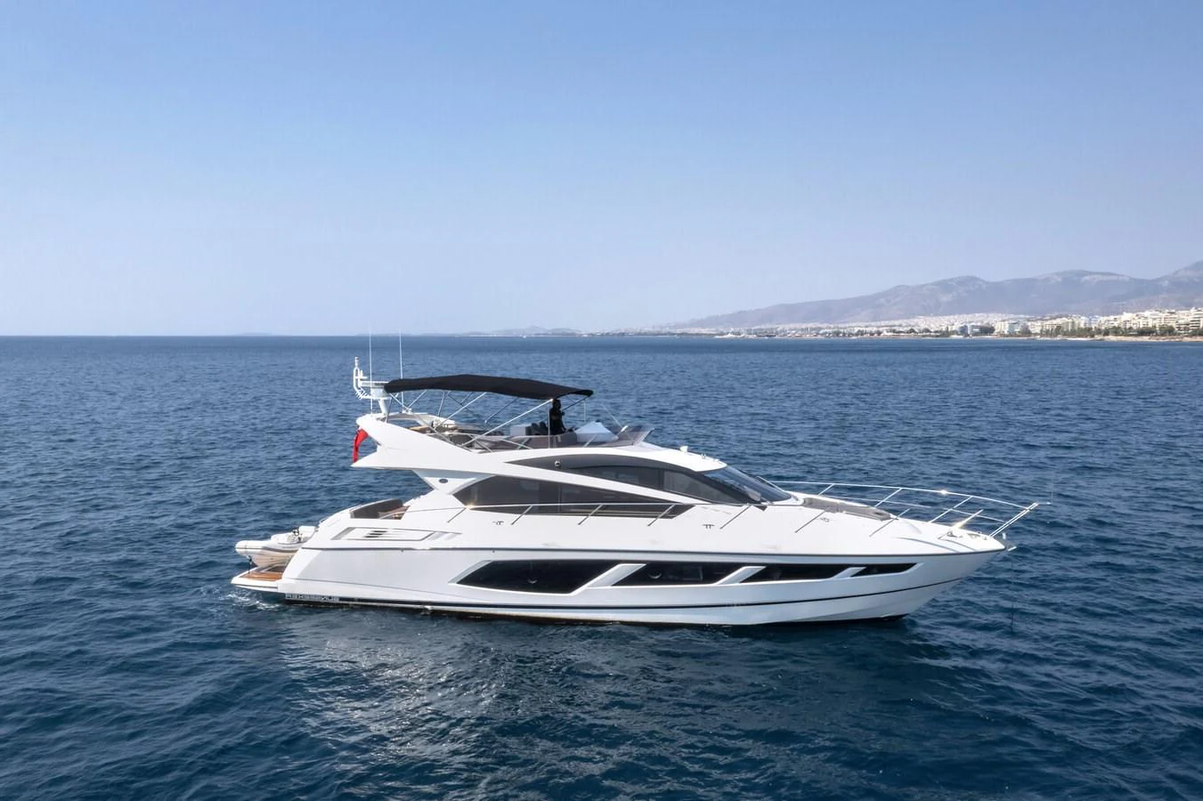 A sleek and modern yacht cruises gracefully on the open water under a clear blue sky. aboard "CORAZON DE LEON" Yacht for Sale