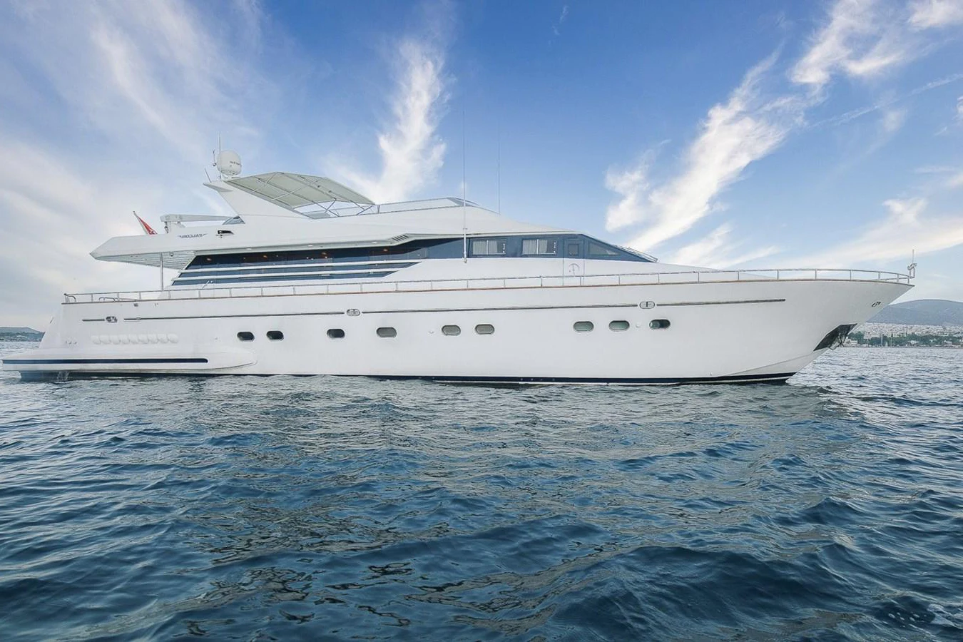 A sleek and elegant yacht glides gracefully on calm waters under a clear blue sky. aboard D-FORCE Yacht for Sale