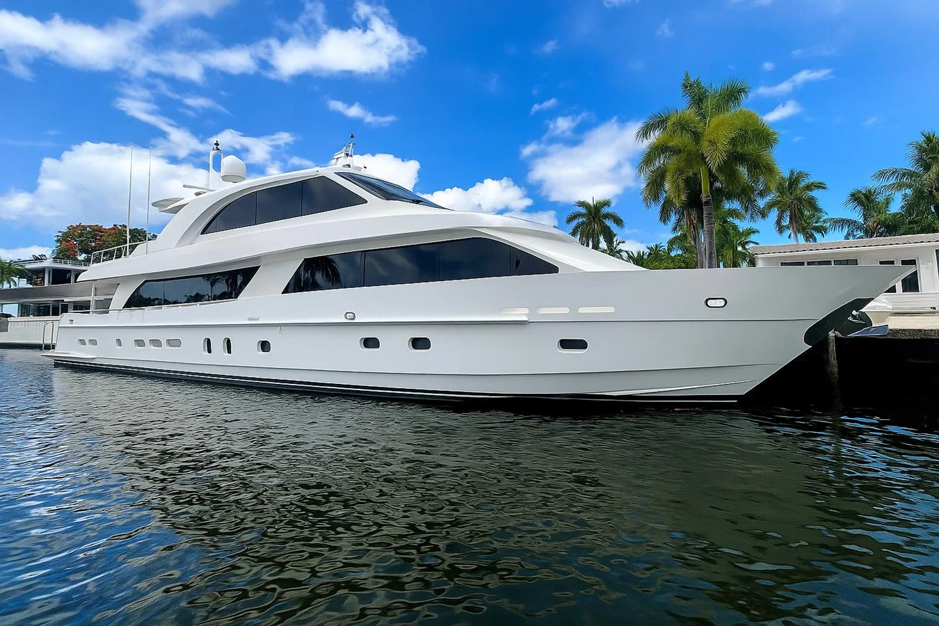 A sleek and modern yacht is docked in a serene marina under a clear blue sky. aboard LUCKY PENNY Yacht for Sale