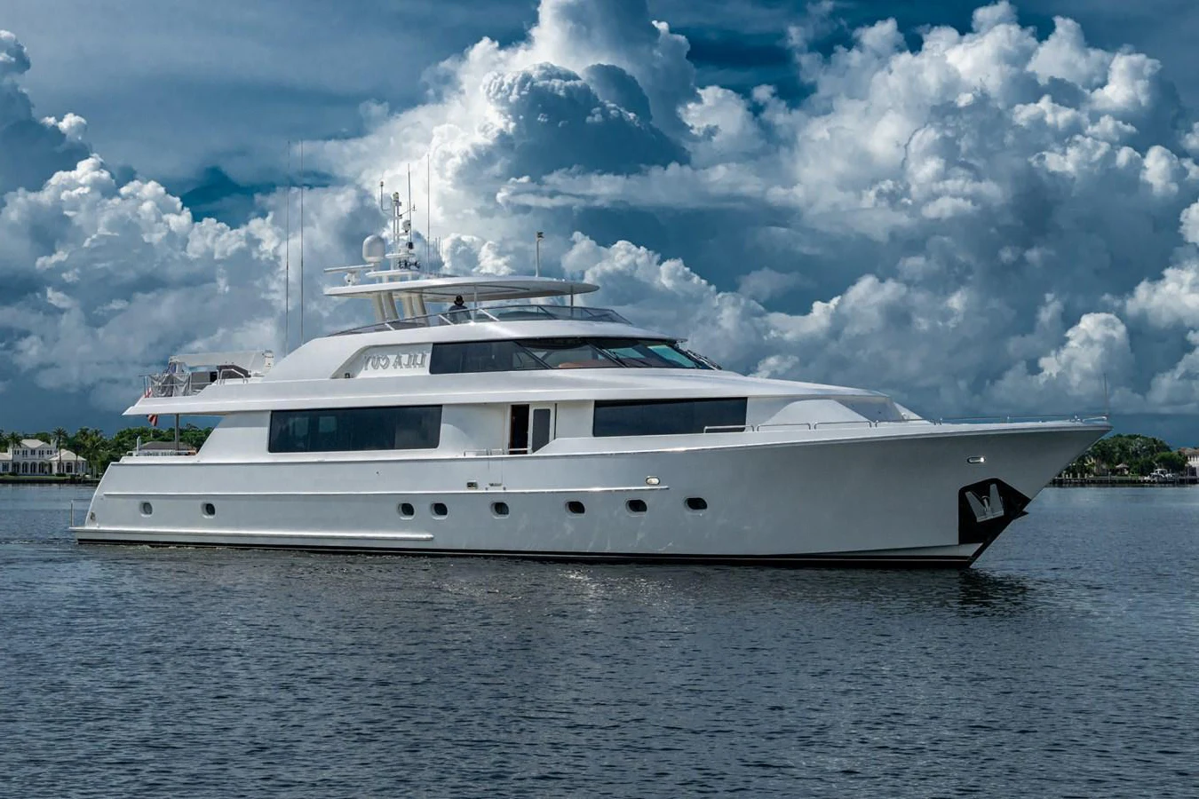 A luxurious yacht cruising on calm waters under a dramatic cloudy sky. aboard LILA CUY Yacht for Sale