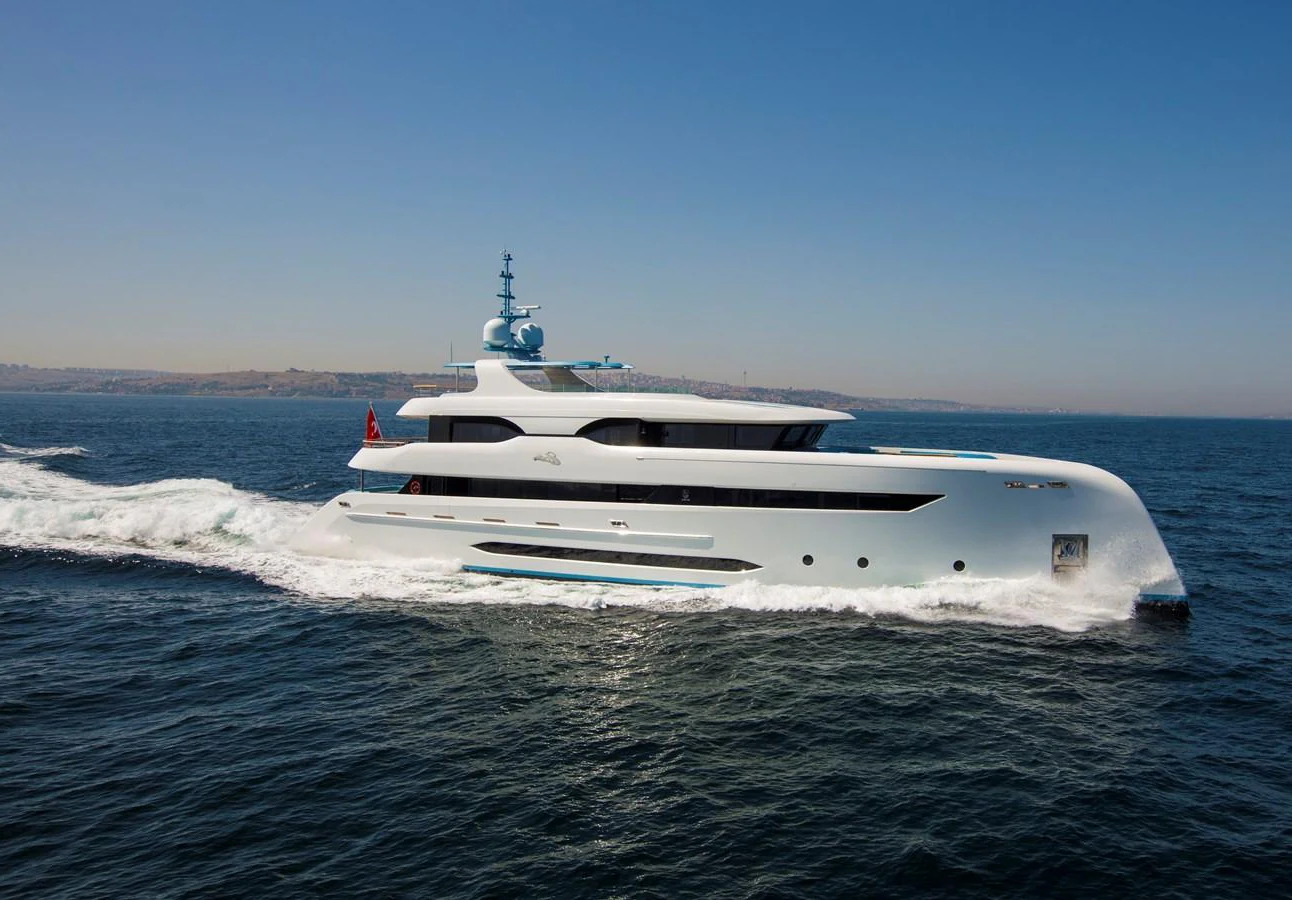 A sleek and modern yacht cruises gracefully on the open water under a clear blue sky. aboard ELADA Yacht for Sale