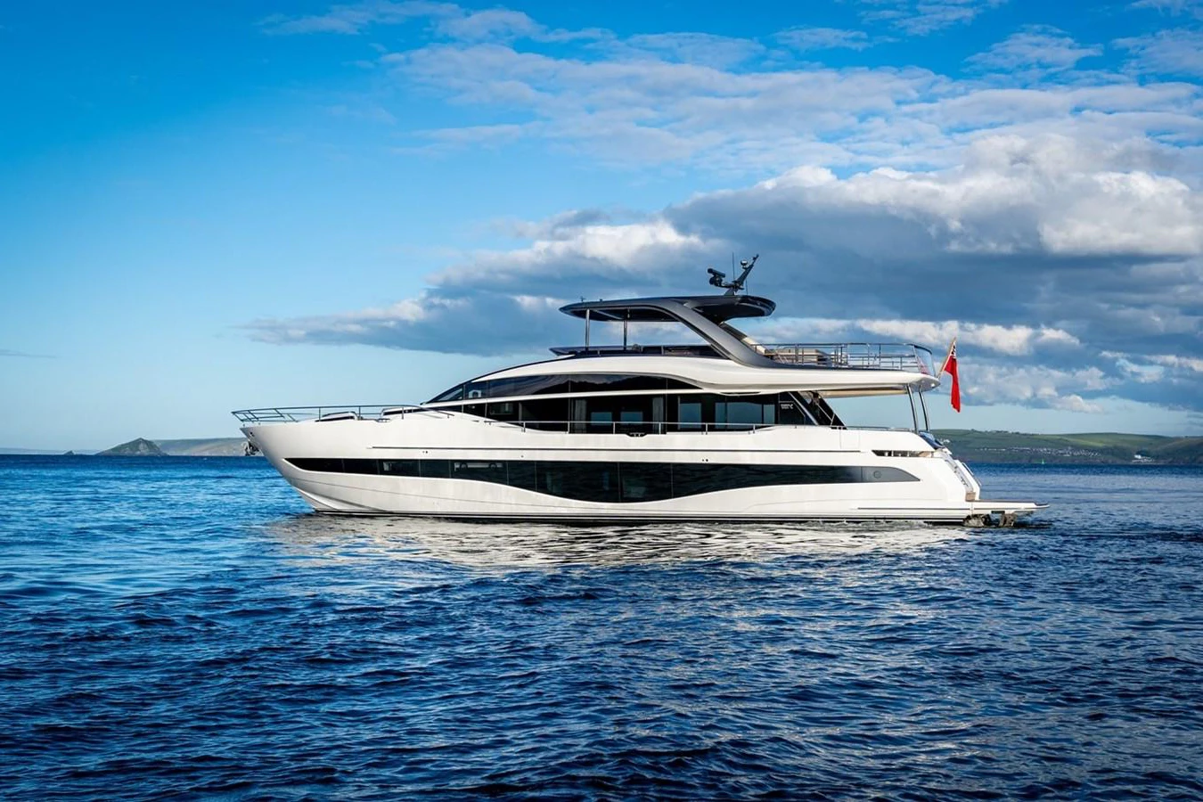 A sleek and modern yacht glides gracefully on calm waters under a clear blue sky. aboard LILYAN Yacht for Sale