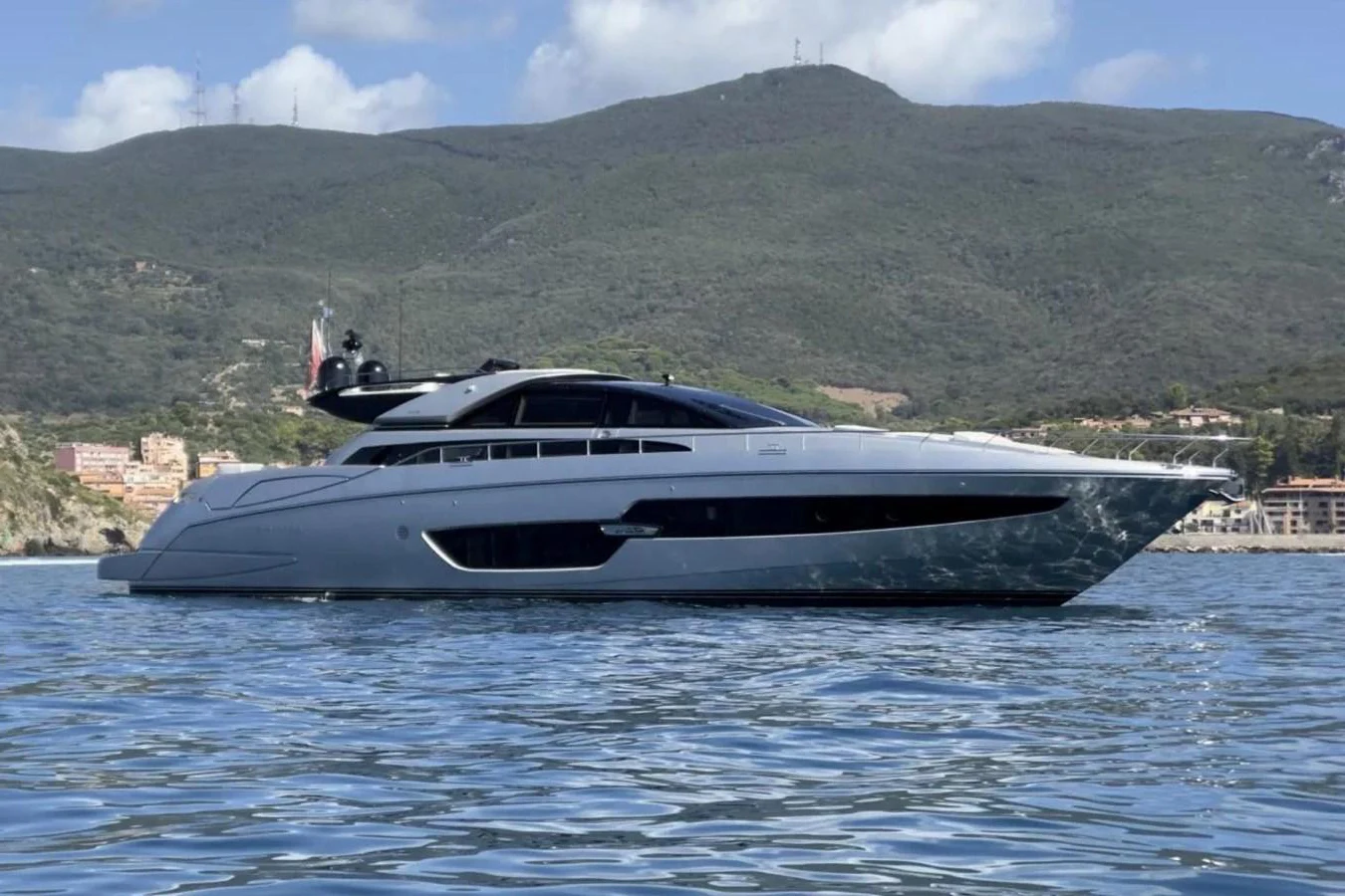 A sleek and modern yacht glides gracefully on calm waters with a scenic mountainous backdrop. aboard SPEEDY BEAR Yacht for Sale