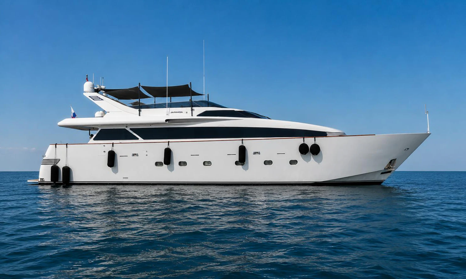 A sleek and modern yacht glides effortlessly on calm waters under a clear blue sky. aboard ALPHERATZ Yacht for Sale