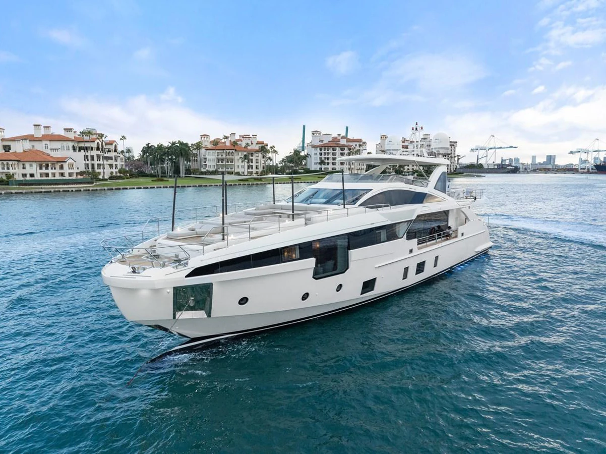 A sleek and modern yacht cruises gracefully on calm waters with a scenic coastal backdrop. aboard AZIMUT GRANDE 32/23 Yacht for Sale