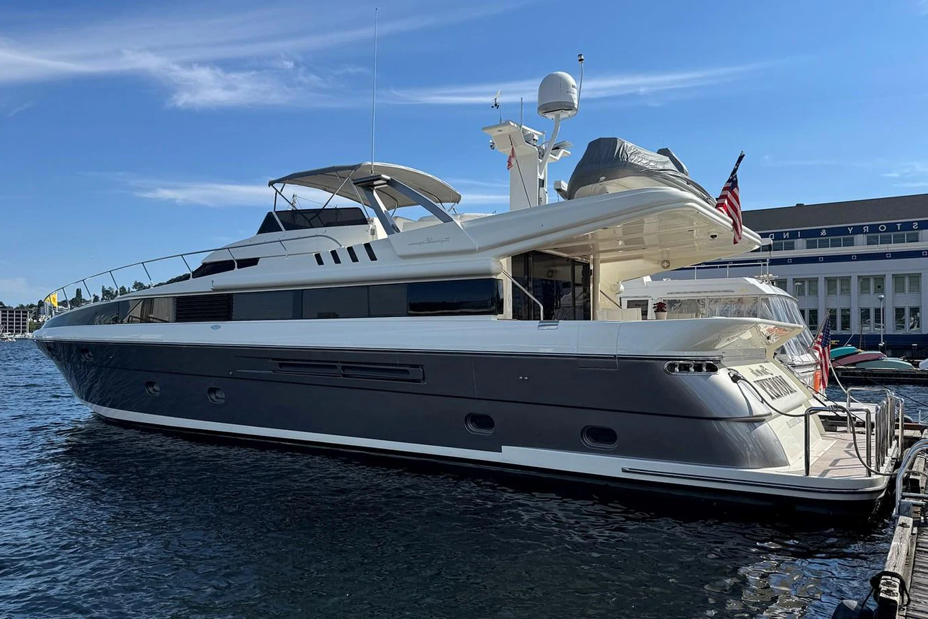 A sleek and modern yacht docked at a marina, showcasing its elegant design and spacious deck. aboard SHOW ME THE MONEY Yacht for Sale