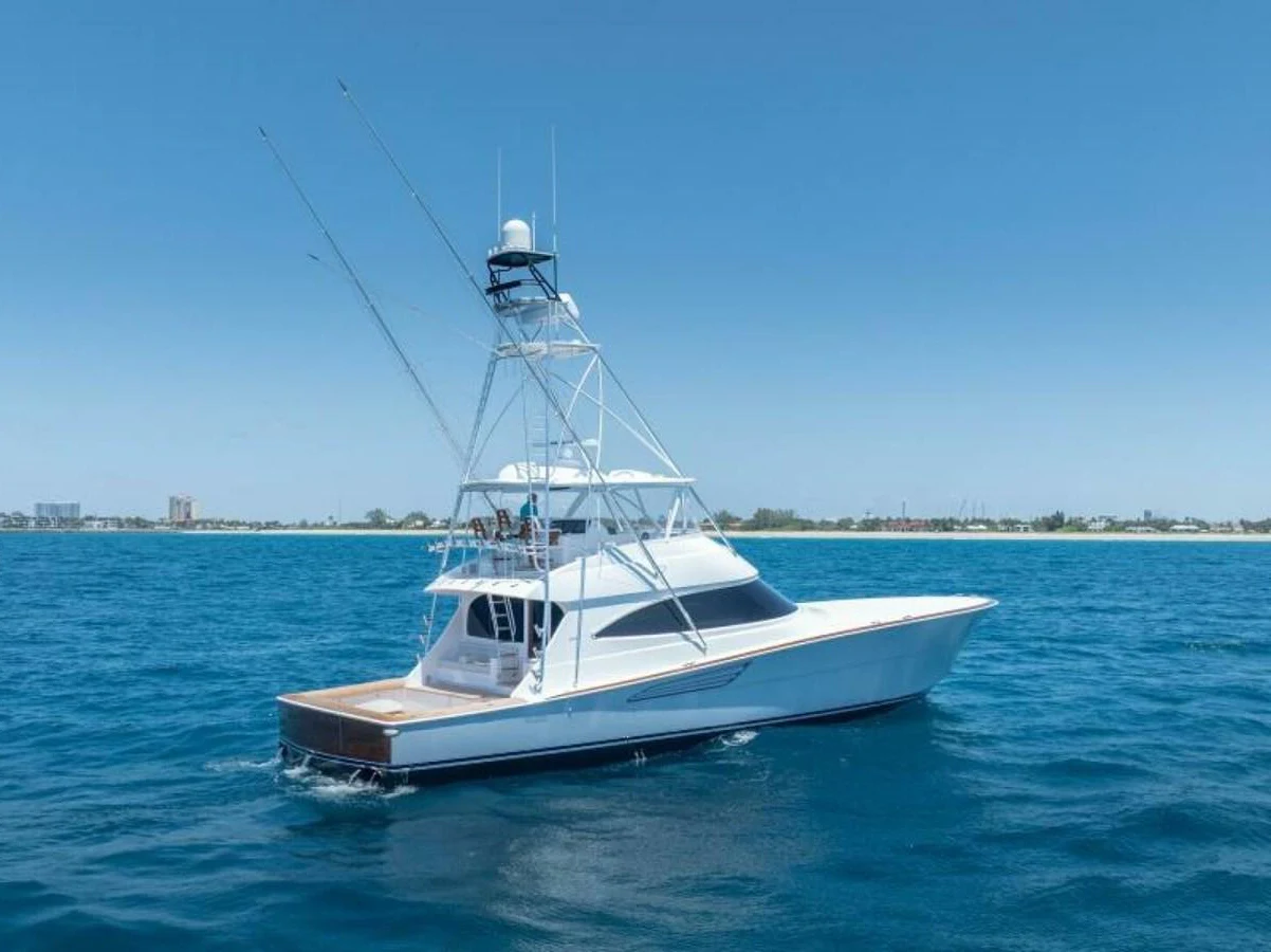 A sleek yacht cruises on the open water under a clear blue sky. aboard 2027 VIKING 74C Yacht for Sale