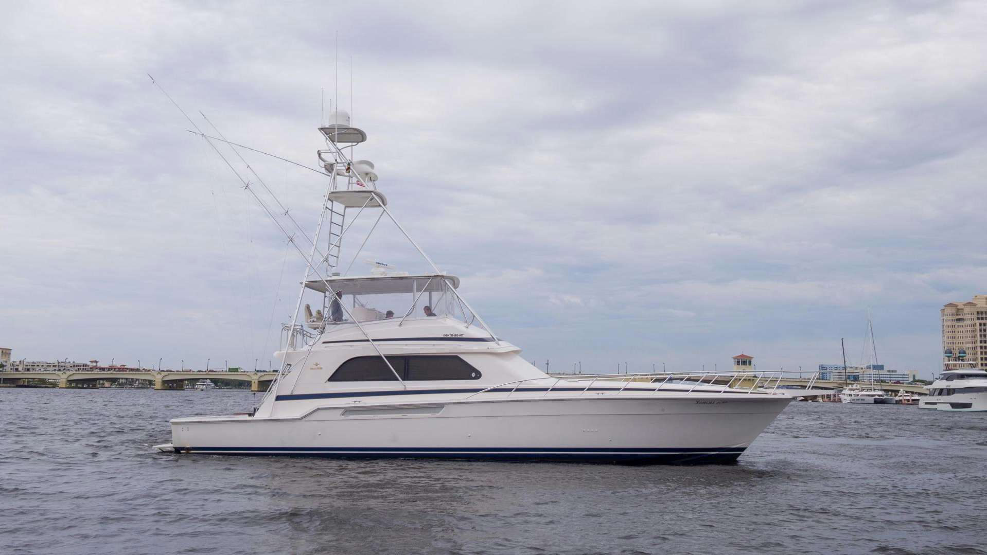 a large white boat in a harbor aboard 60' BERTRAM 2004 Yacht for Sale