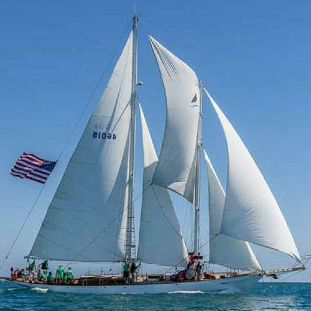 a sailboat with a flag on it aboard CURLEW Yacht for Sale