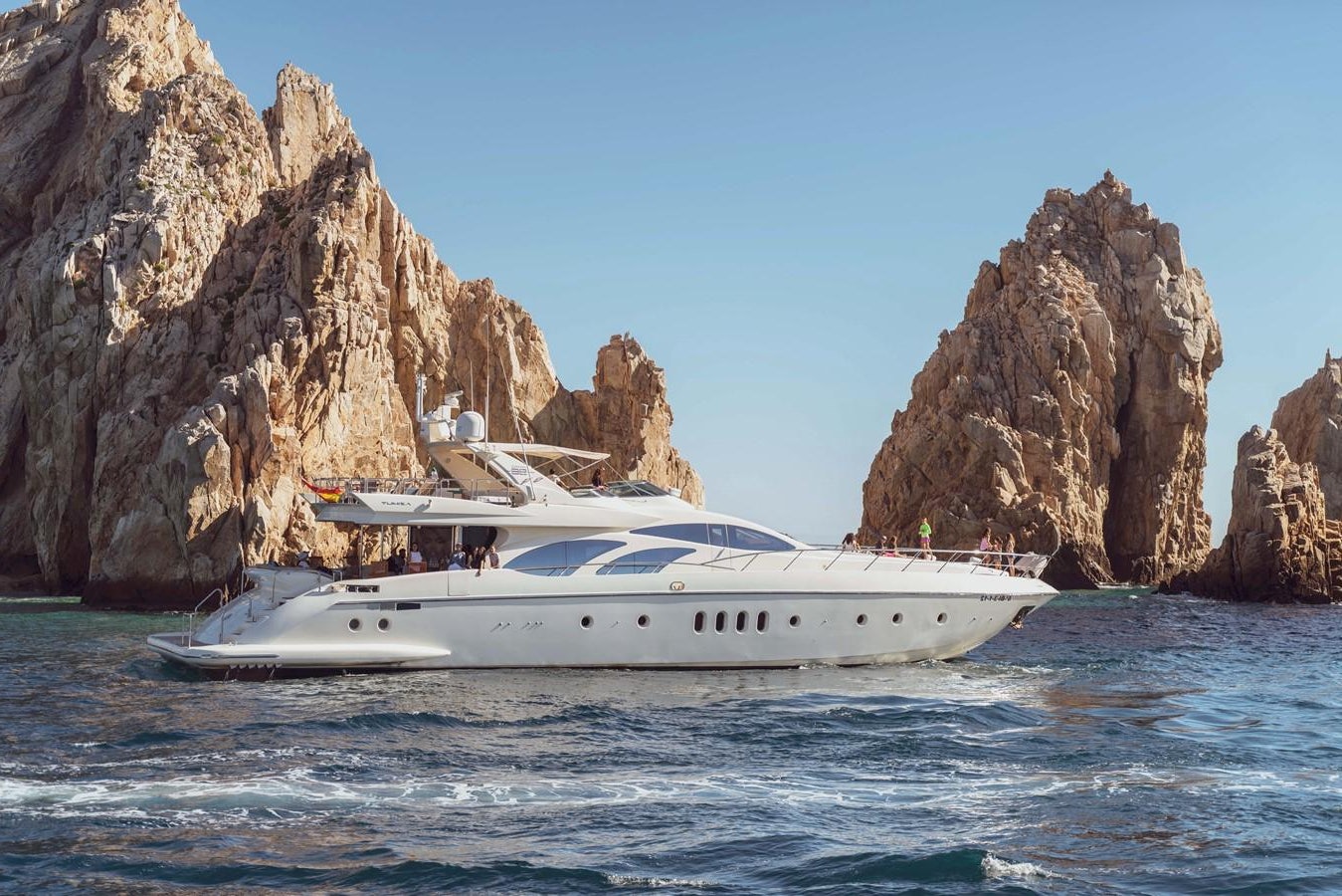 a boat in the water with Arch of Cabo San Lucas in the background aboard GANESH A Yacht for Sale
