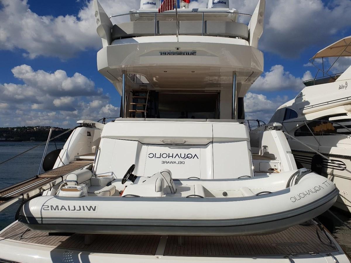 a white boat on a dock aboard AQUAHOLIC Yacht for Sale