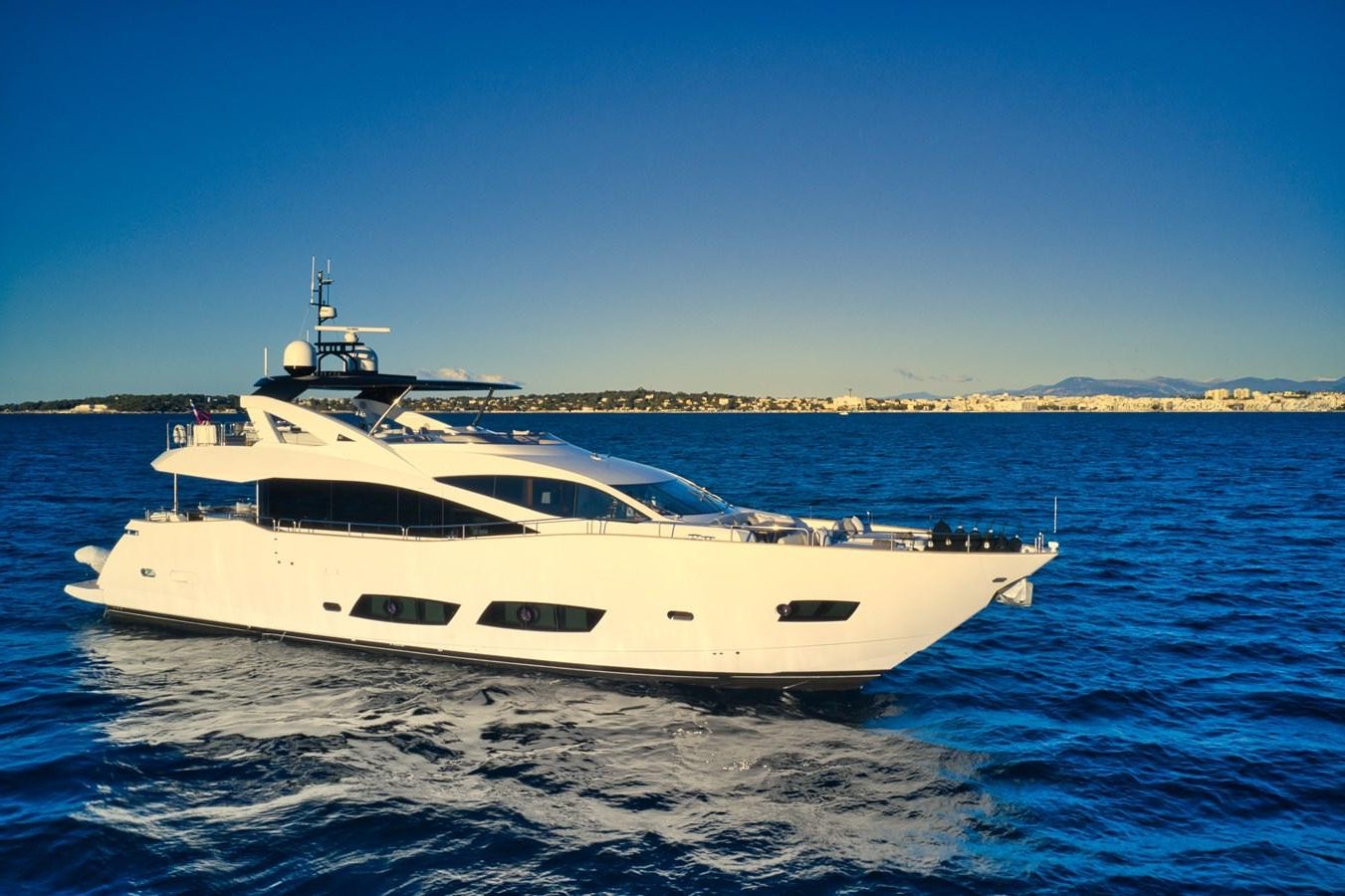 a white yacht in the water aboard KUDOS Yacht for Sale