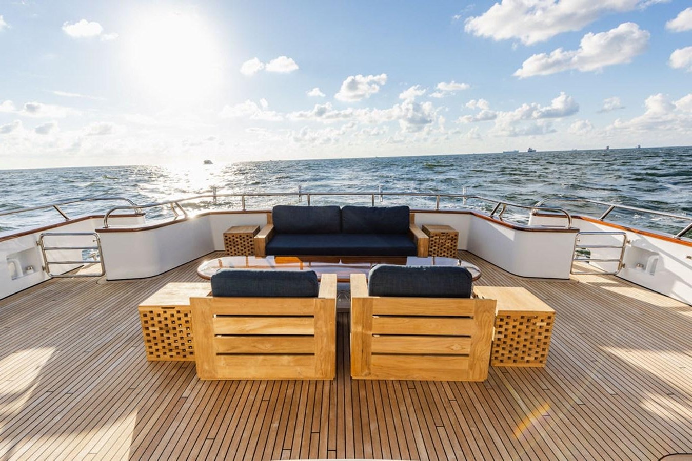 a deck with chairs and a table on it aboard EMPIRE SEA Yacht for Sale