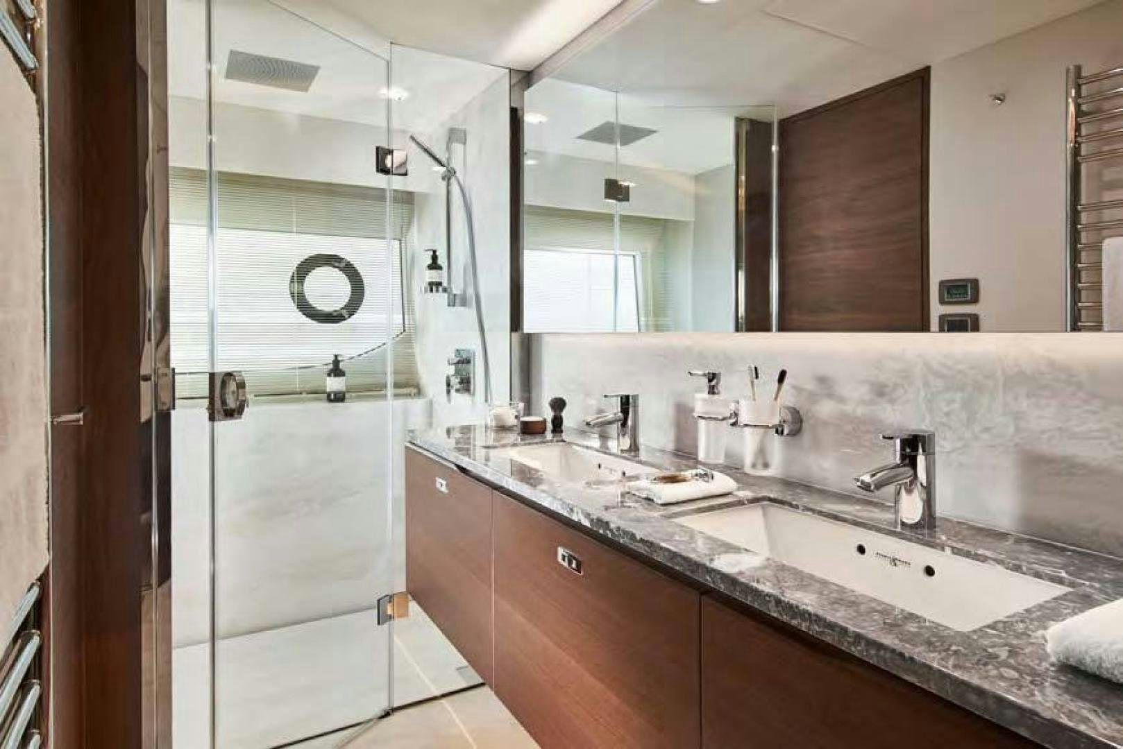 a bathroom with a glass shower aboard Y85 Yacht for Sale