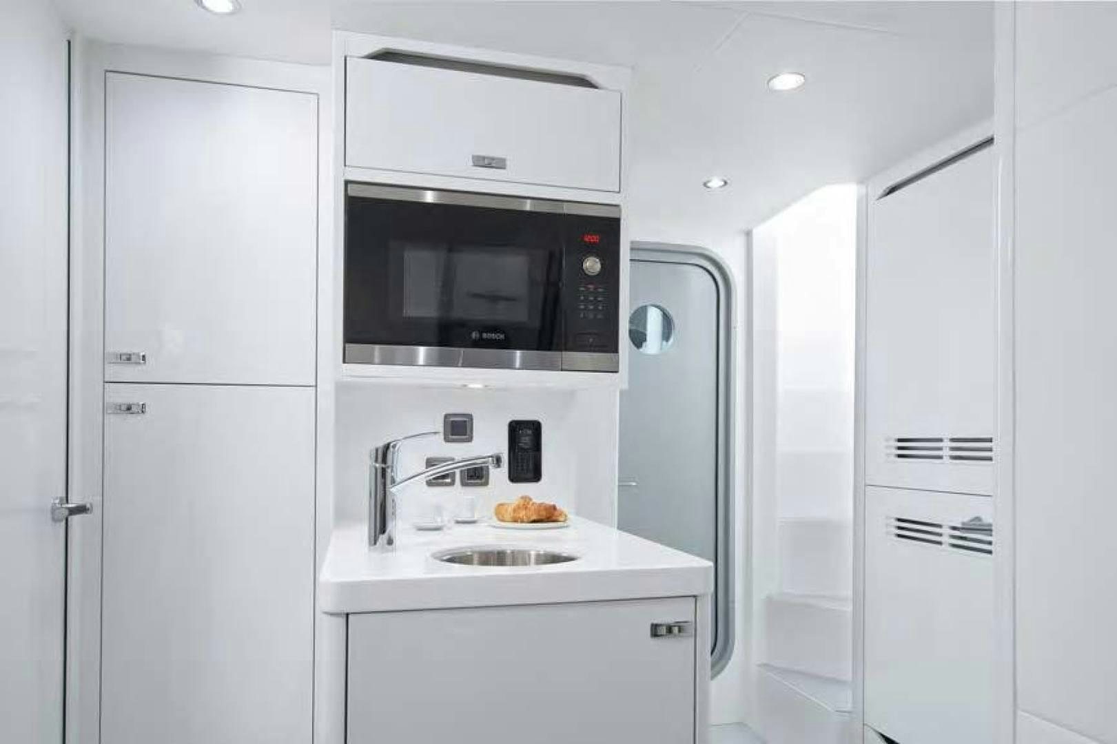 a white kitchen with white cabinets aboard Y85 Yacht for Sale