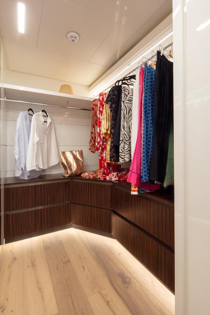 a closet with clothes on the wall aboard ATOM Yacht for Sale