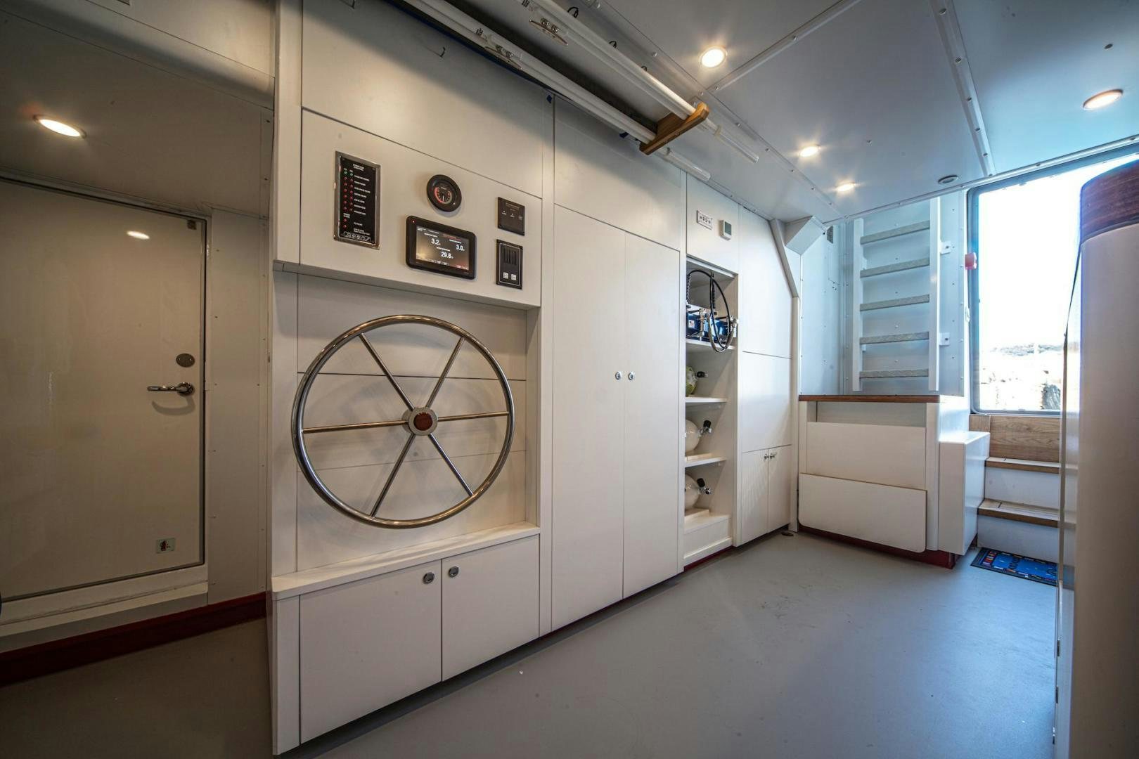a room with a large white wall and a bicycle on the wall aboard ATOM Yacht for Sale