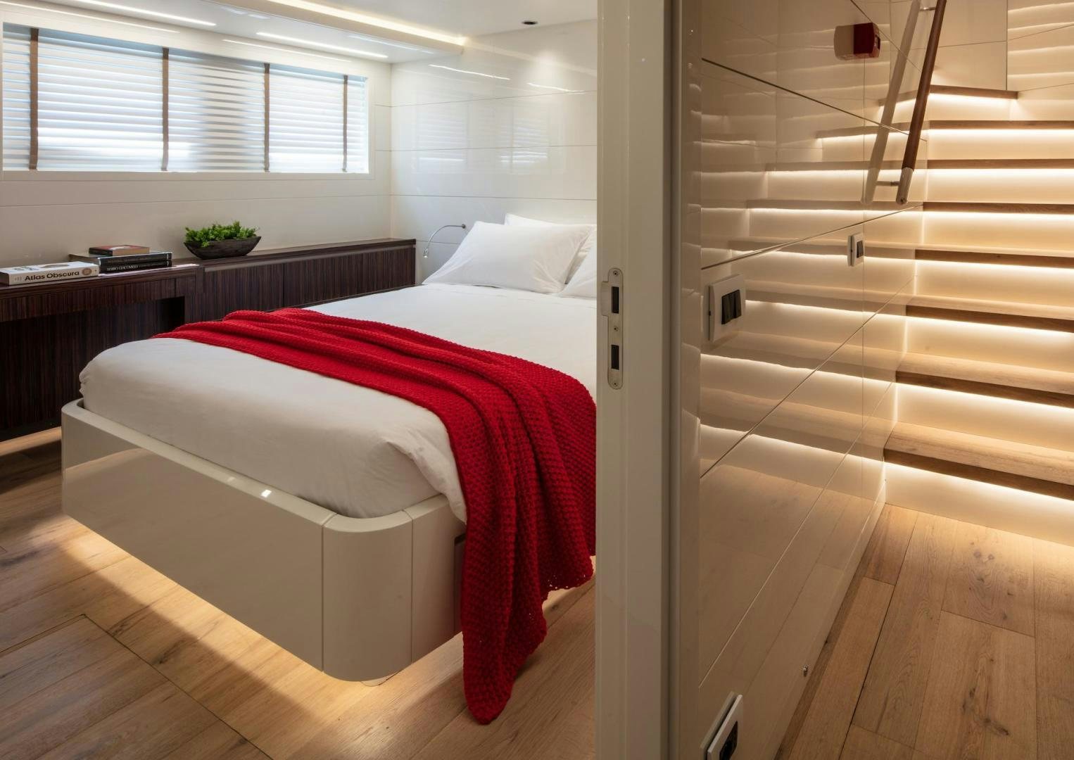 a bedroom with a bed and a desk aboard ATOM Yacht for Sale