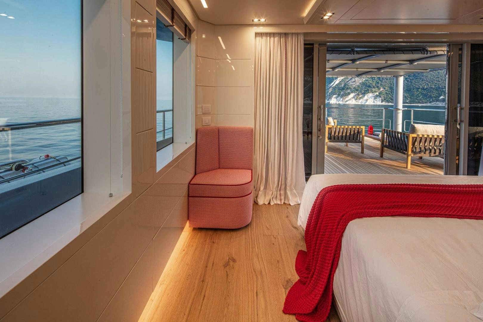 a room with a bed and a chair aboard ATOM Yacht for Sale