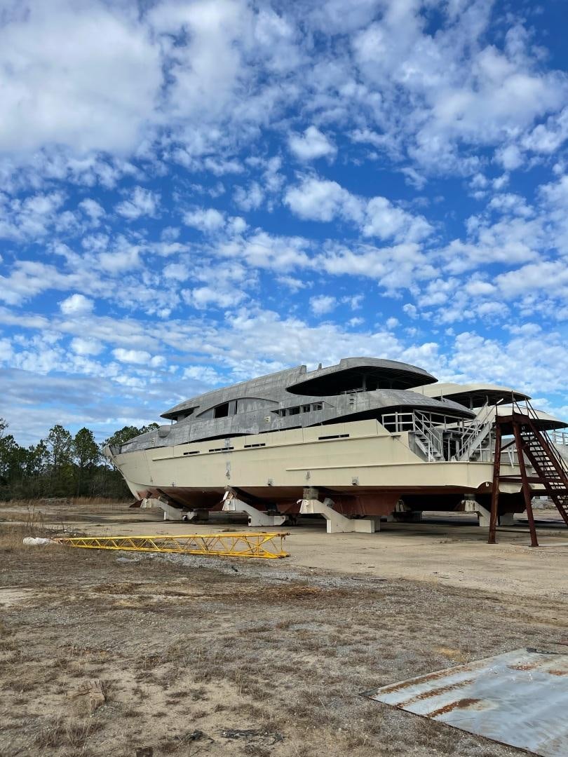 a white boat on a beach aboard TRINITY T052 Yacht for Sale