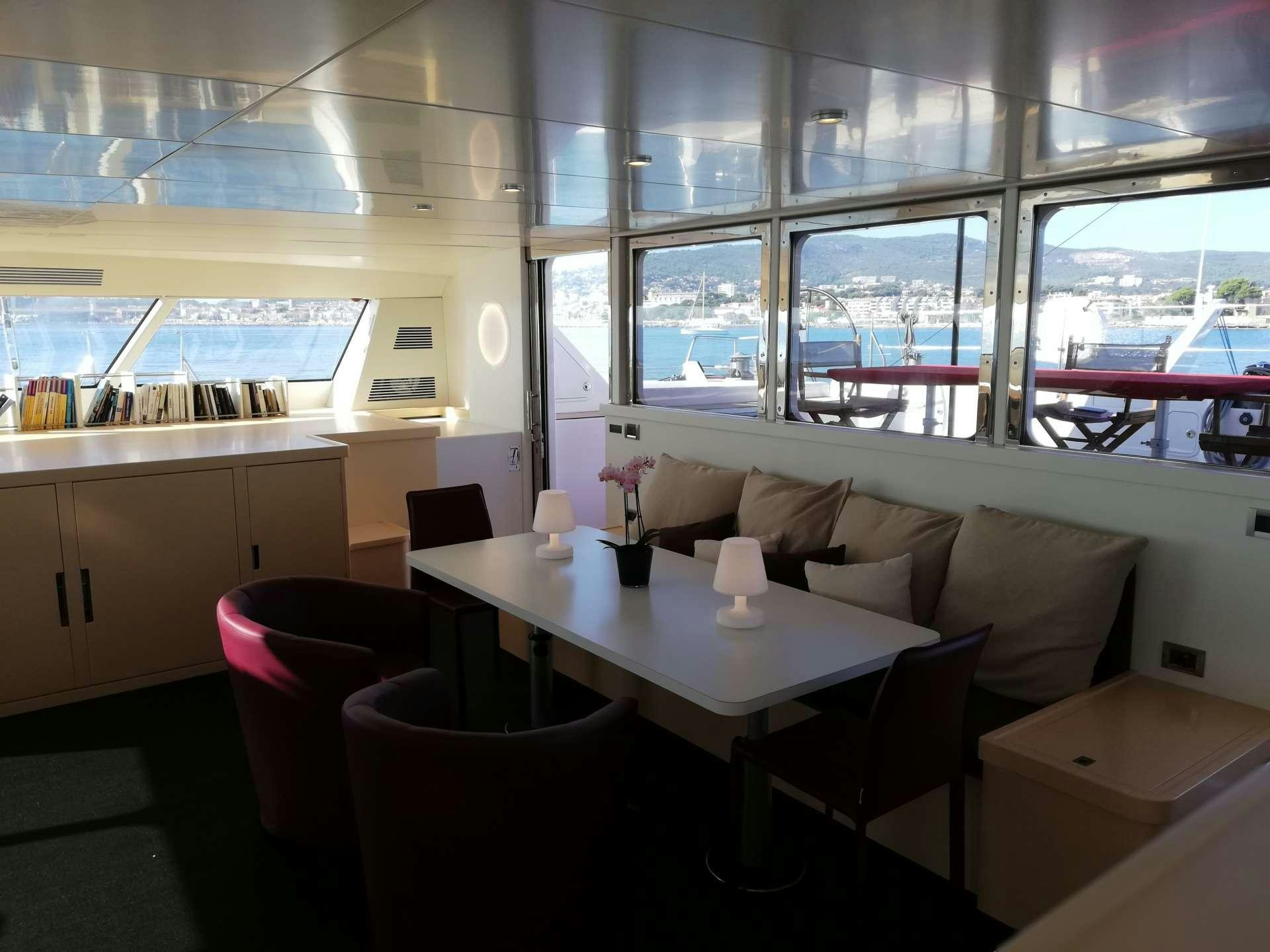 a room with a couch and a table and chairs aboard TAJ Yacht for Charter