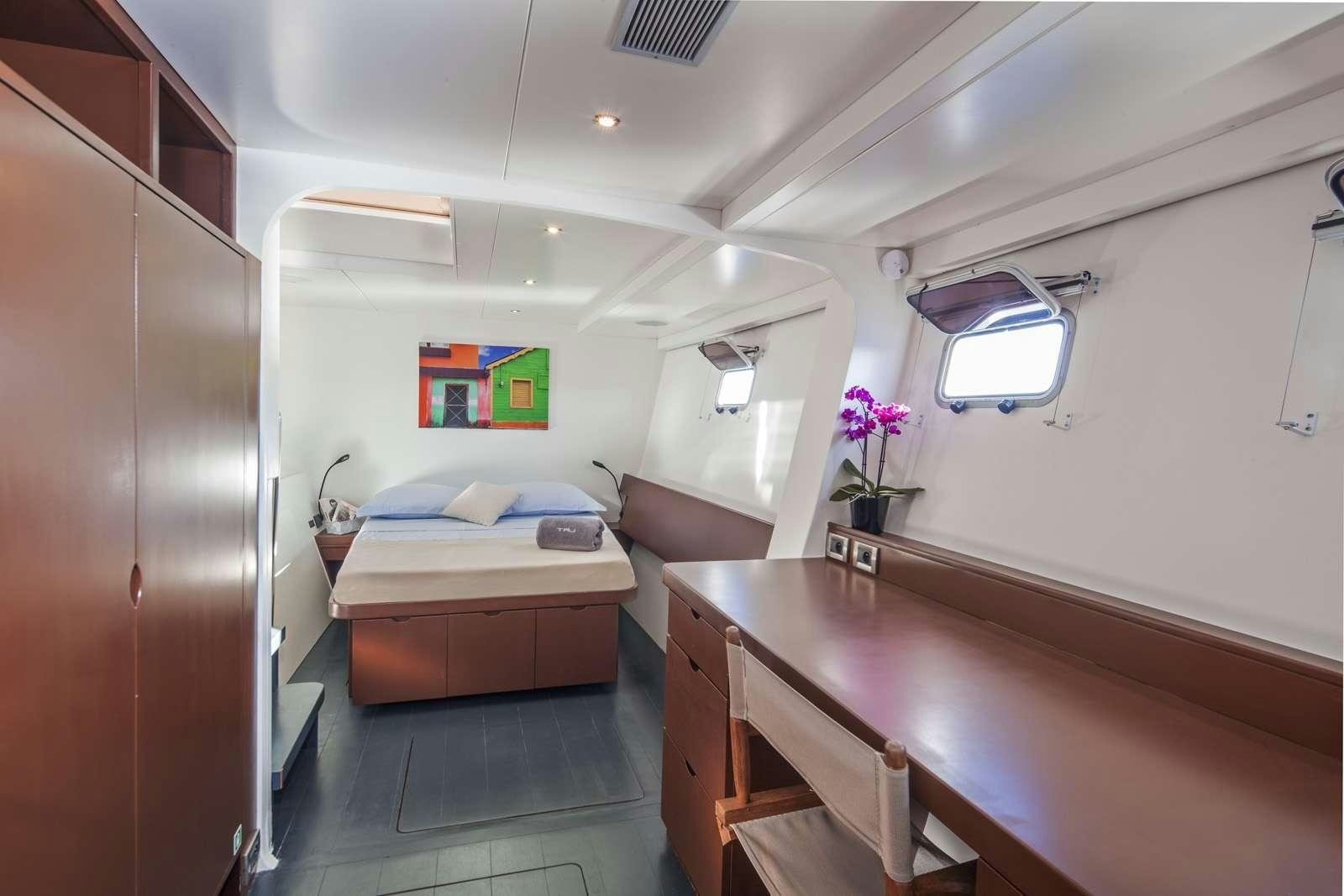 a room with a bed and desk aboard TAJ Yacht for Charter