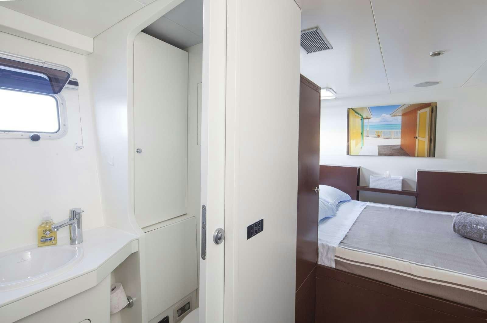 a room with a bed and a sink aboard TAJ Yacht for Charter