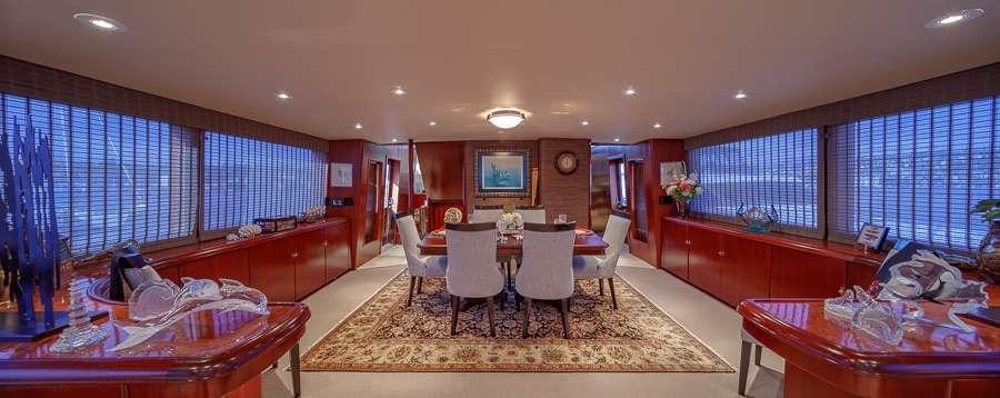 a large living room with a dining table and chairs aboard BLACKWOOD Yacht for Charter