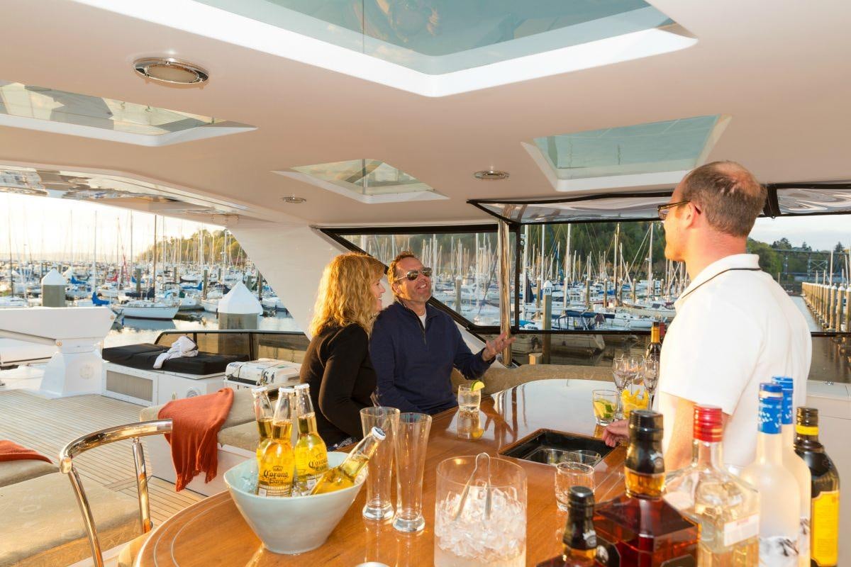 a group of people sitting at a table with glasses of wine aboard BLACKWOOD Yacht for Charter