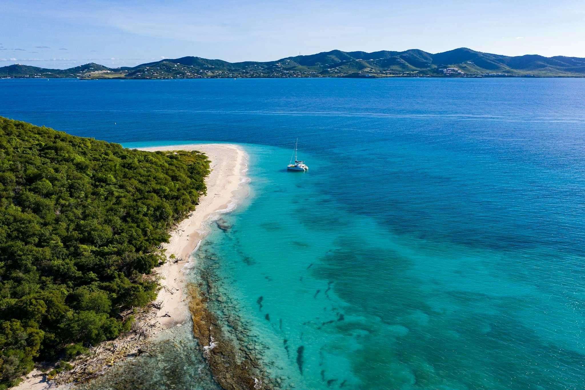 a beach with a boat in the water aboard TIME OUT Yacht for Charter