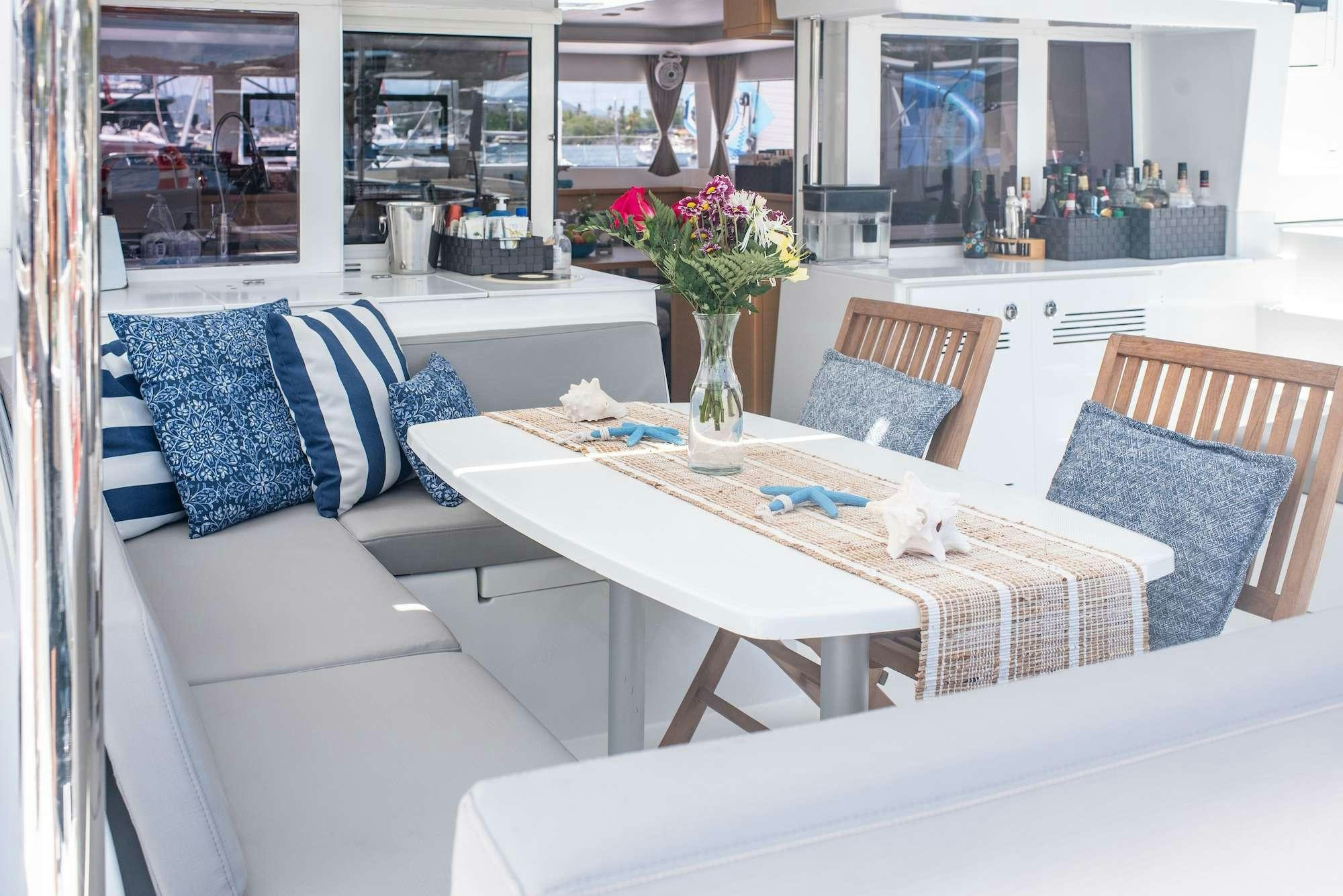 a table with chairs and a vase of flowers on it aboard TIME OUT Yacht for Charter