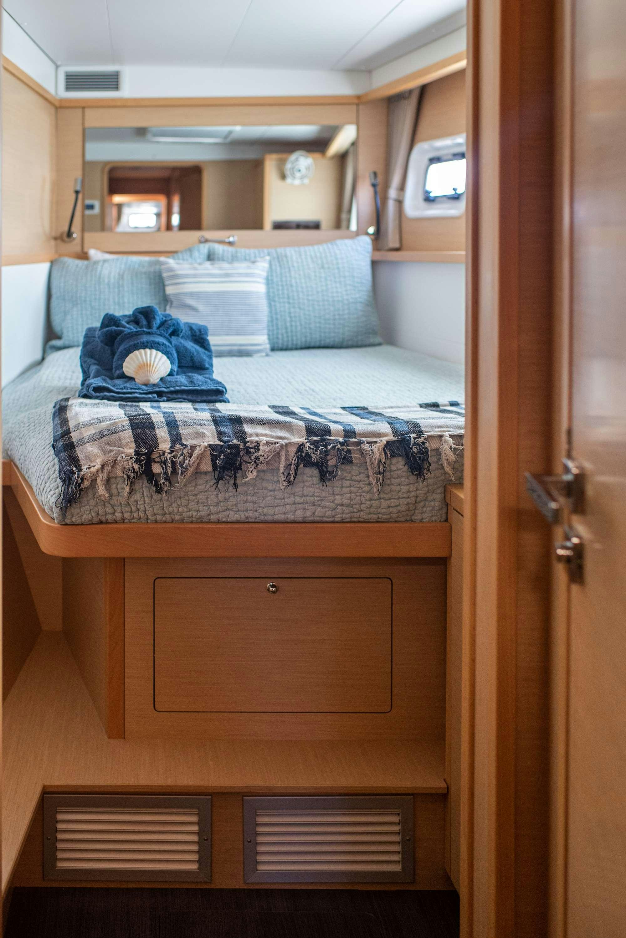 a bed with a blue blanket aboard TIME OUT Yacht for Charter
